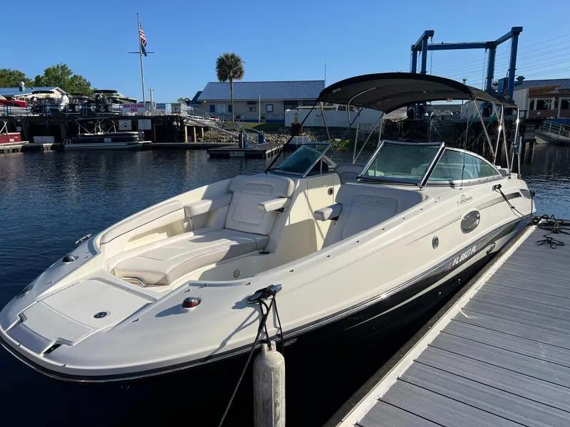 Slide: The Image of 2012 Sea Ray 260 Sundeck boat docked at marina under clear blue sky. - 30