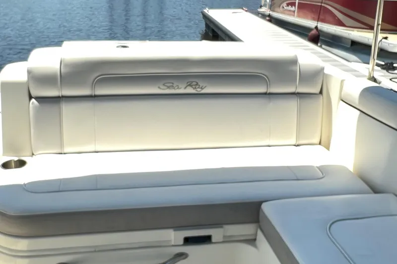 Slide: The Image of 2012 Sea Ray 260 Sundeck boat interior with white seating near a dock. - 33