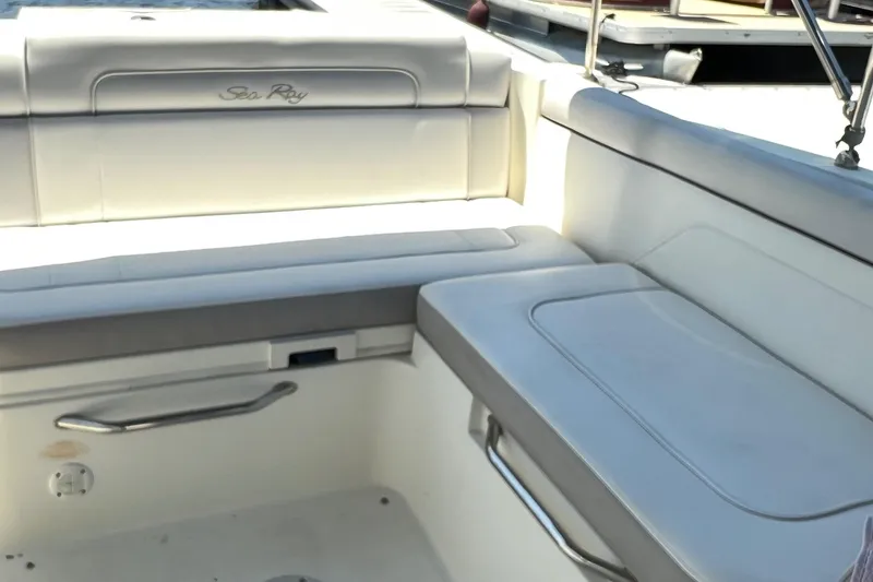 Slide: The Image of 2012 Sea Ray 260 Sundeck interior seating with white upholstery and stainless steel accents. - 34