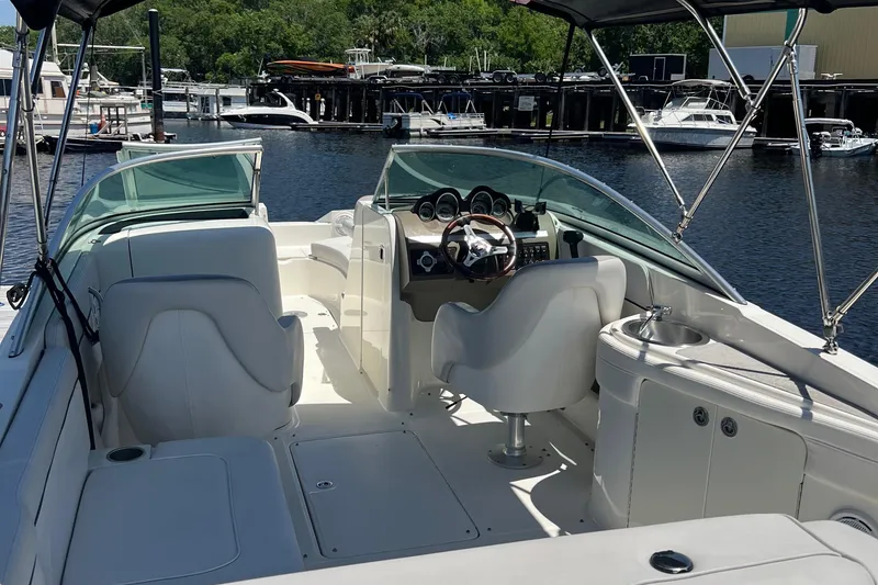 Slide: The Image of 2012 Sea Ray 260 Sundeck boat interior with helm, seating, and marina background. - 40