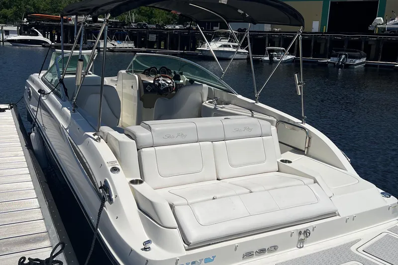 Slide: The Image of 2012 Sea Ray 260 Sundeck boat docked, featuring spacious seating and canopy. - 6