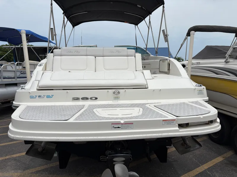 Slide: The Image of 2012 Sea Ray 260 Sundeck boat with white seating and canopy, docked in a marina. - 8