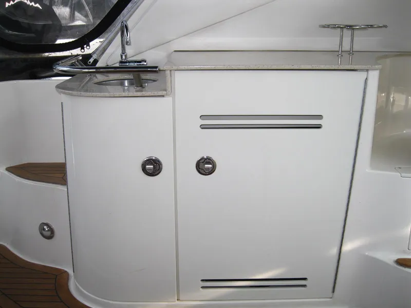 Slide: The Image of 2011 Sea Ray 350 Sundancer boat interior with sink and storage cabinets. - 13