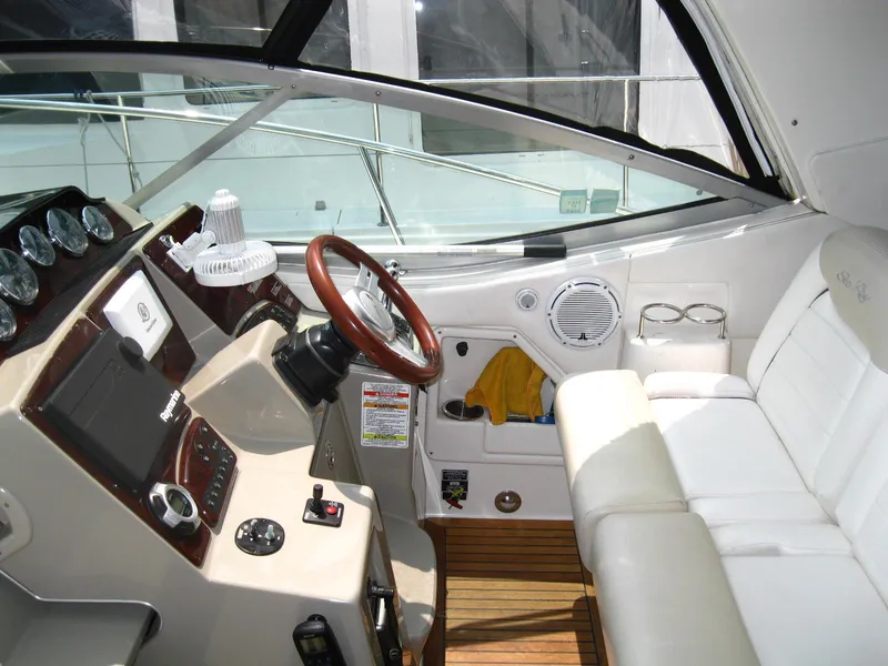 Slide: The Image of 2011 Sea Ray 350 Sundancer helm with leather seating and wooden accents. - 17