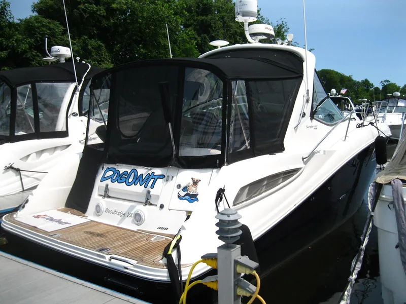 Slide: The Image of 2011 Sea Ray 350 Sundancer docked, featuring sleek design and black canopy. - 2