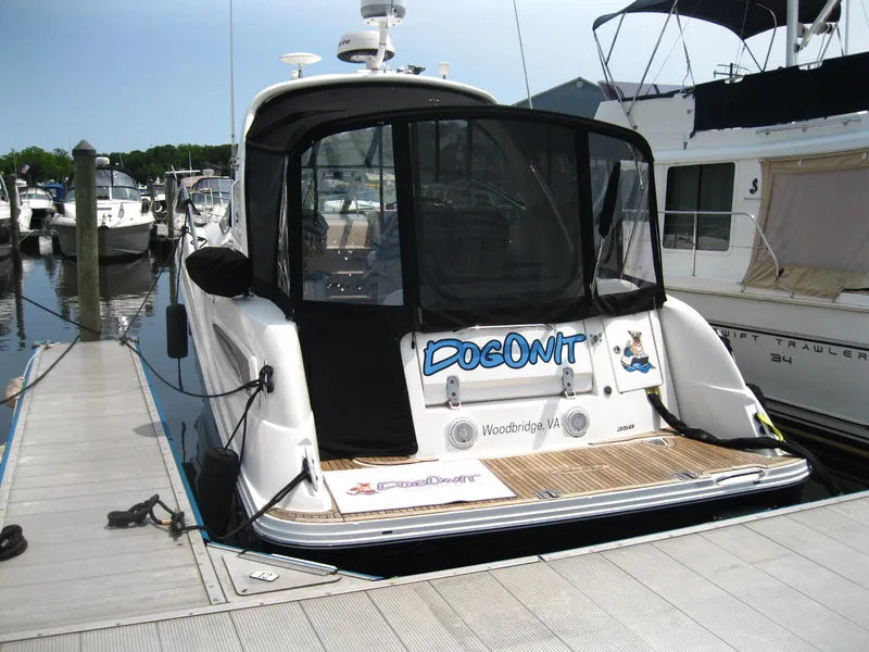 Slide: The Image of 2011 Sea Ray 350 Sundancer docked, featuring a black canopy and wooden deck. - 3