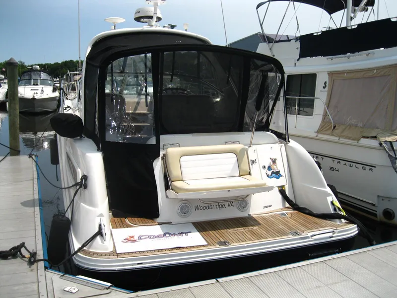 Slide: The Image of 2011 Sea Ray 350 Sundancer docked, featuring a spacious rear deck and seating area. - 4