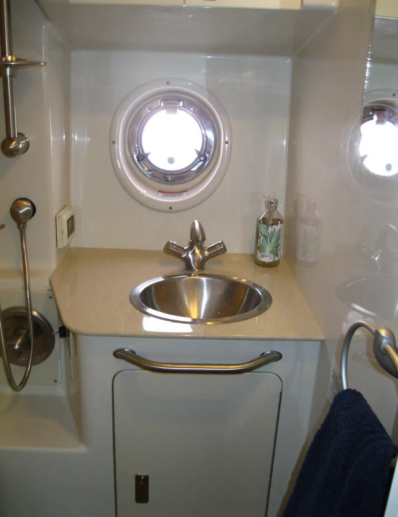 Slide: The Image of 2011 Sea Ray 350 Sundancer bathroom with sink, porthole, and showerhead. - 42