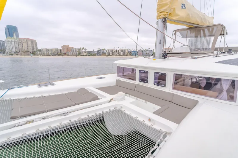 Slide: The Image of 2016 Lagoon 450F catamaran with spacious deck and city skyline in the background. - 49