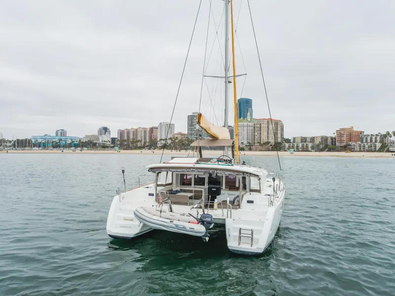 Slide: The Image of 2016 Lagoon 450F catamaran anchored near city skyline, calm waters, overcast sky. - 9