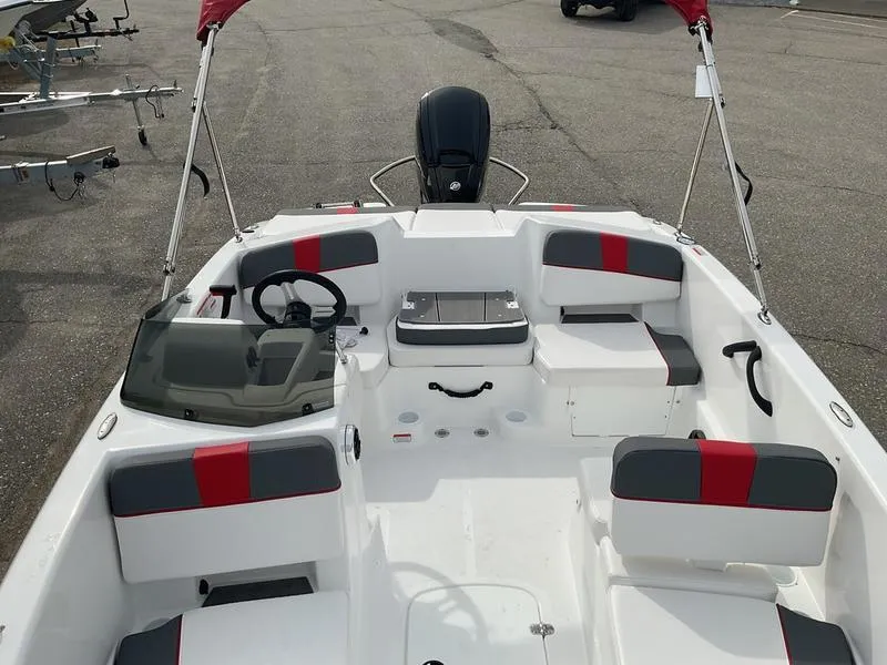 Slide: The Image of 2025 Tahoe T18 boat interior with red and gray seating, steering wheel, and motor. - 10