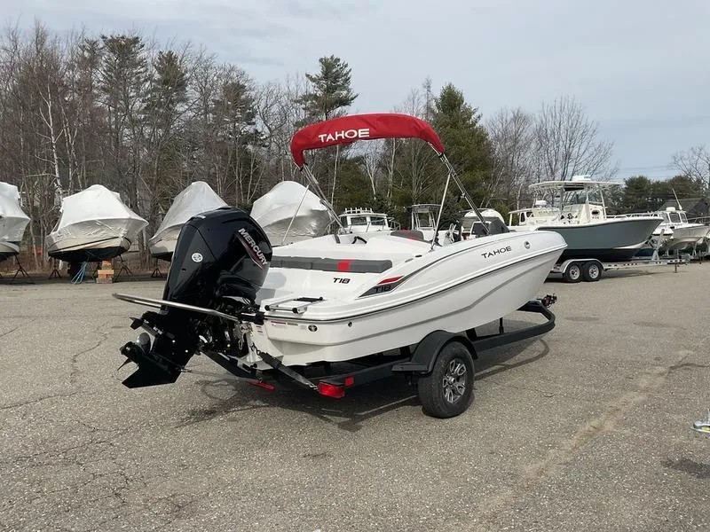 Slide: The Image of 2025 Tahoe T18 boat with red canopy on trailer in outdoor setting. - 4