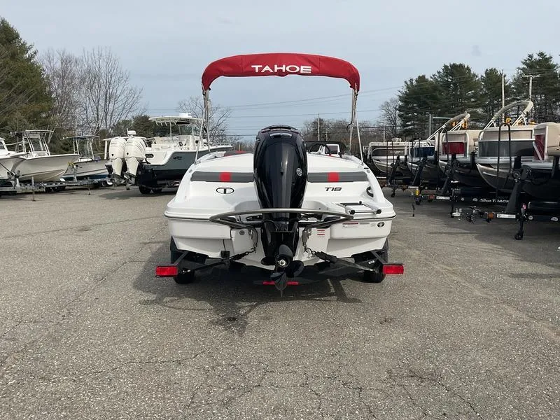 Slide: The Image of 2025 Tahoe T18 boat with red canopy, parked in a marina lot. - 5