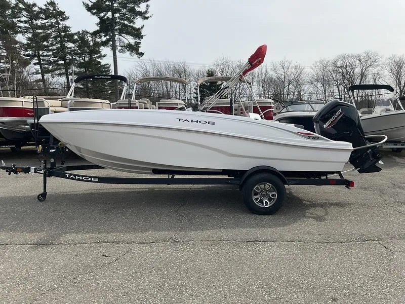 Slide: The Image of 2025 Tahoe T18 boat on trailer, parked outdoors with other boats in the background. - 8