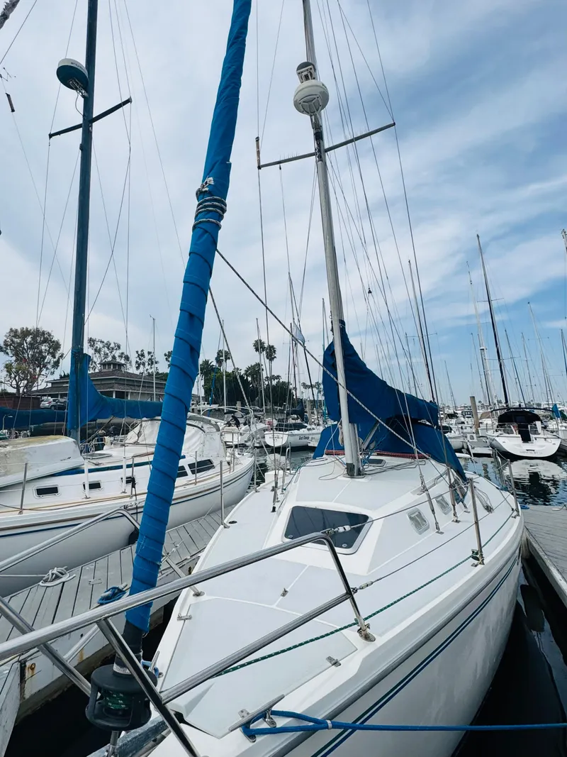 Slide: The Image of 1994 Catalina 320 sailboat docked in marina under cloudy sky. - 13