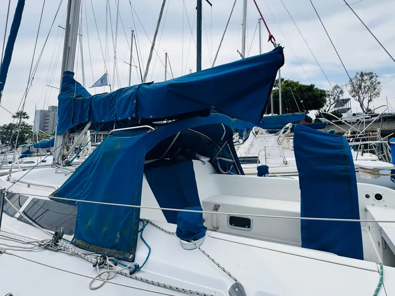 Slide: The Image of 1994 Catalina 320 sailboat with blue covers docked at a marina. - 15