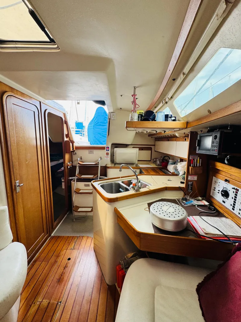 Slide: The Image of Interior of a 1994 Catalina 320 sailboat with wooden cabinetry and compact kitchen. - 23