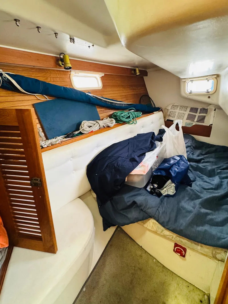 Slide: The Image of Interior cabin of a 1994 Catalina 320 sailboat with storage and bedding. - 24