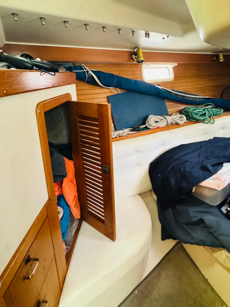 Slide: The Image of Interior of 1994 Catalina 320 sailboat with storage, ropes, and seating area. - 25