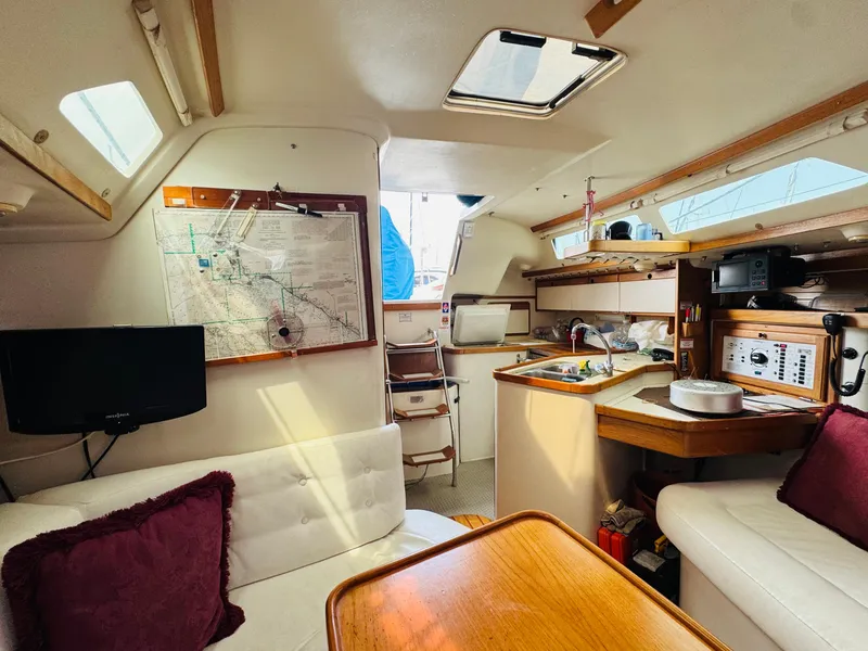Slide: The Image of Interior of a 1994 Catalina 320 sailboat with cozy seating and navigation equipment. - 28