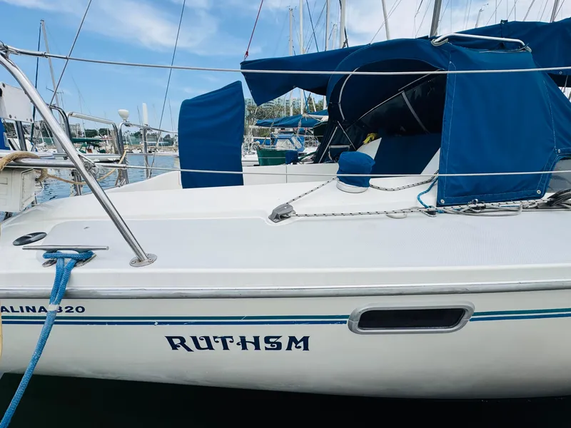 Slide: The Image of Sailboat Catalina 320, 1994 model, docked with blue covers and visible name "RUTHSM". - 3