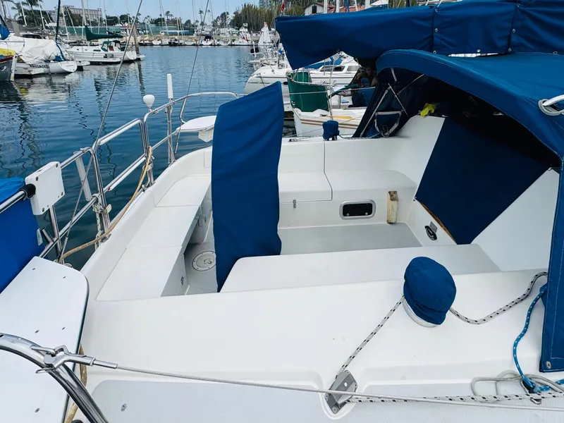 Slide: The Image of 1994 Catalina 320 sailboat with blue covers docked in a marina. - 4