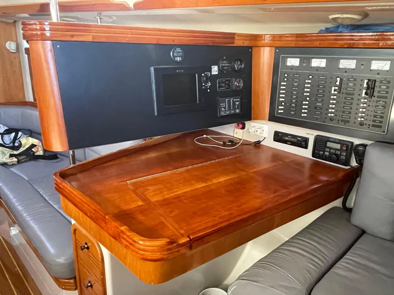 Slide: The Image of Navigation station inside 2001 C&C 121 sailboat with control panels and wooden desk. - 40