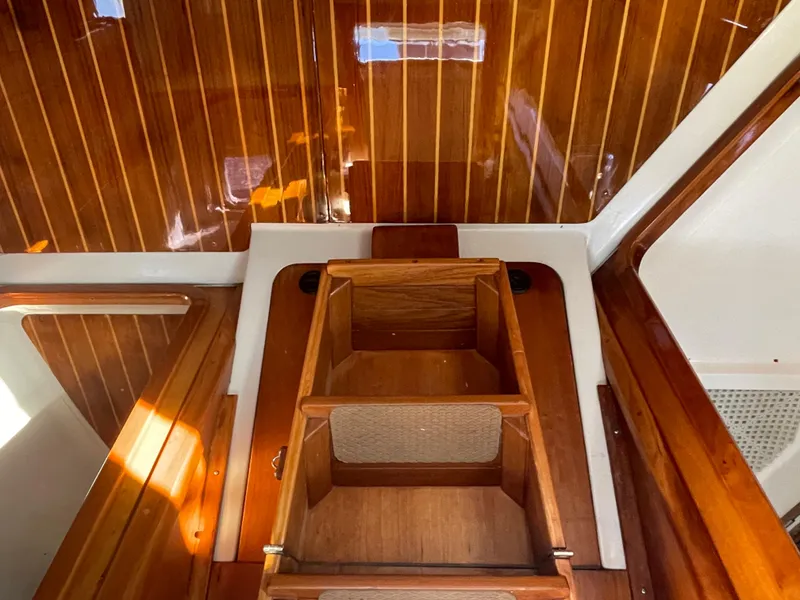 Slide: The Image of Interior of 2001 C&C 121 sailboat with polished wood finish and storage compartments. - 41