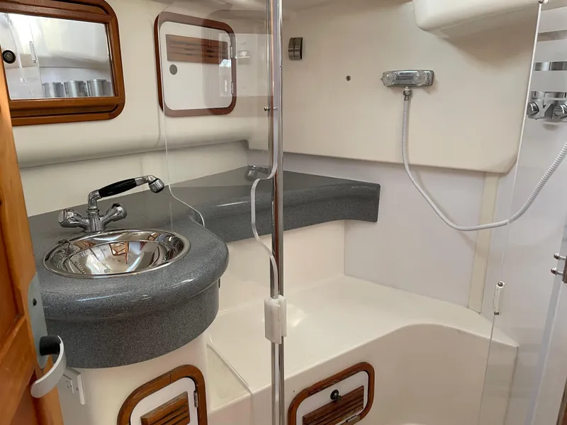 Slide: The Image of Compact boat bathroom with sink, shower, and wooden accents in a 2001 C&C 121 model. - 45