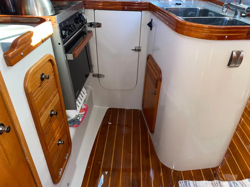 Slide: The Image of 2001 C&C 121 yacht interior kitchen with wood accents and modern appliances. - 46