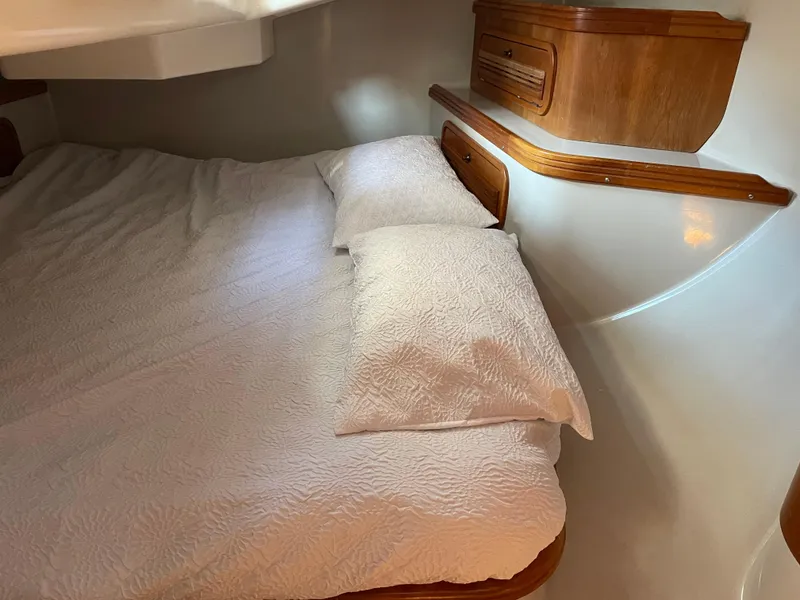 Slide: The Image of Cozy cabin interior of 2001 C&C 121 sailboat with wooden accents and white bedding. - 49