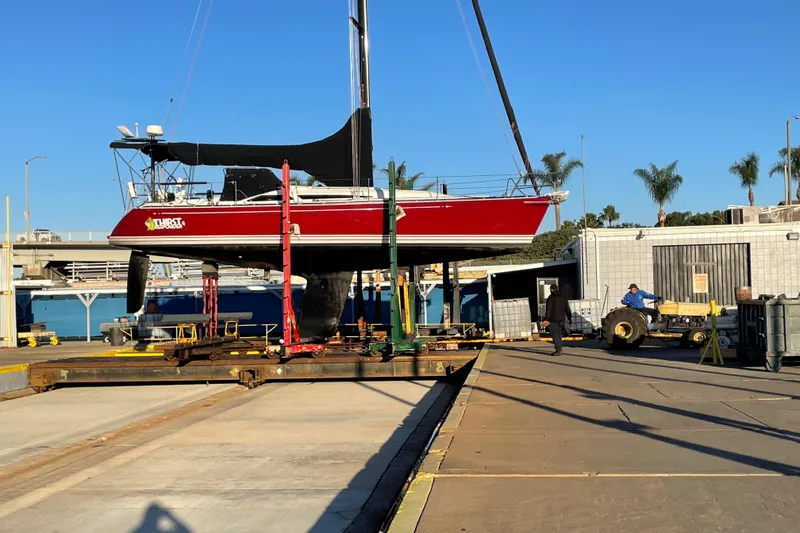 Slide: The Image of Red C&C 121 sailboat from 2001 on a lift at a marina. - 5