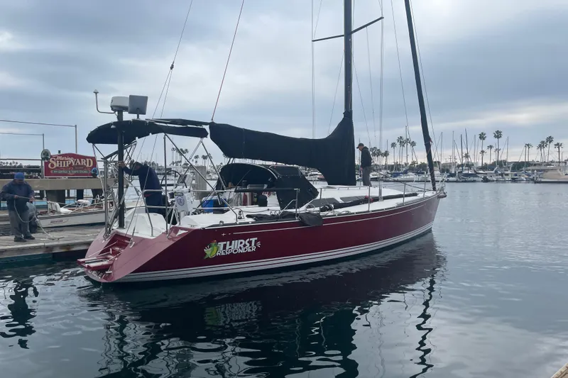 Slide: The Image of Red C&C 121 sailboat docked at marina, overcast sky, 2001 model. - 6