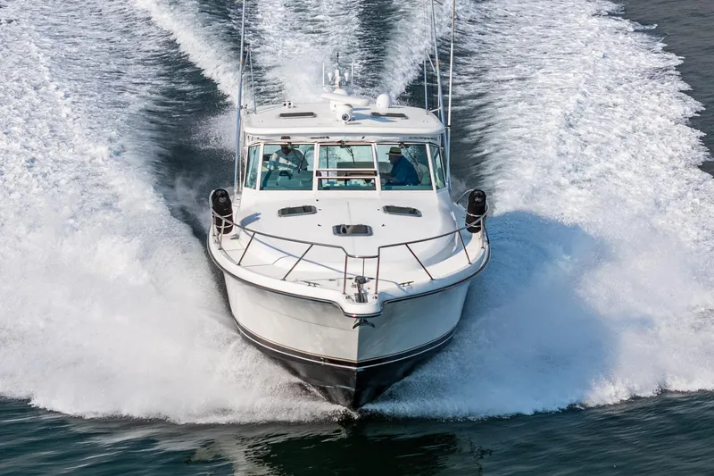 Slide: The Image of 2002 Tiara Yachts 4100 Open cruising on water, creating a dynamic wake. - 0