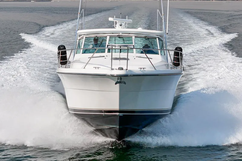 Slide: The Image of 2002 Tiara Yachts 4100 Open cruising on water, front view, creating waves. - 1