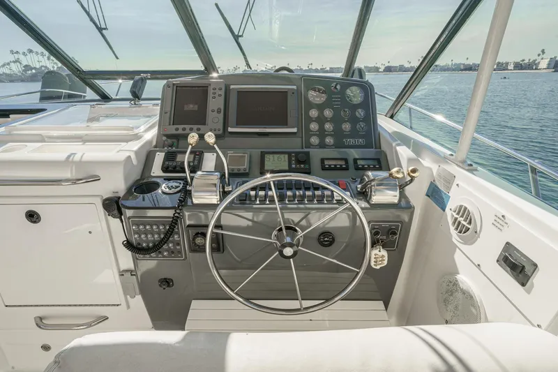 Slide: The Image of 2002 Tiara Yachts 4100 Open helm with navigation instruments and steering wheel, overlooking the water. - 15