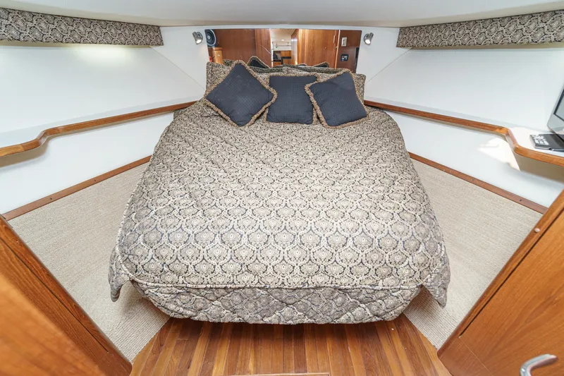 Slide: The Image of Luxurious cabin interior of 2002 Tiara Yachts 4100 Open with elegant bedding and wood accents. - 27