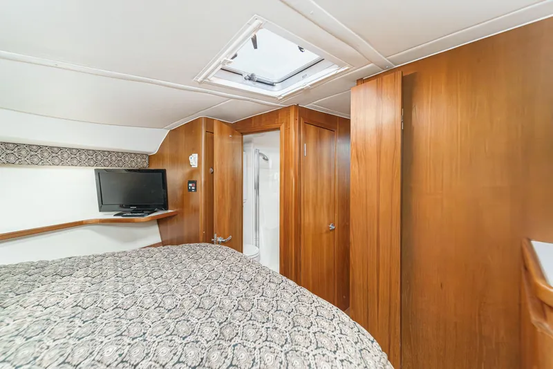 Slide: The Image of 2002 Tiara Yachts 4100 Open cabin interior with wood paneling and TV. - 28