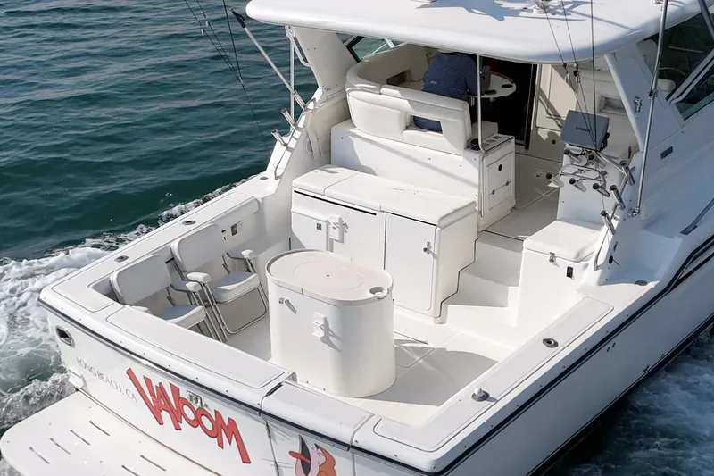 Slide: The Image of 2002 Tiara Yachts 4100 Open cruising on water, featuring spacious deck and seating area. - 8
