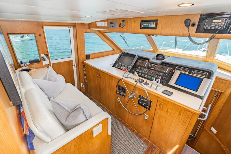 Slide: The Image of 1996 Hatteras 70 Sport Deck Motor Yacht helm with modern navigation equipment and comfortable seating. - 15