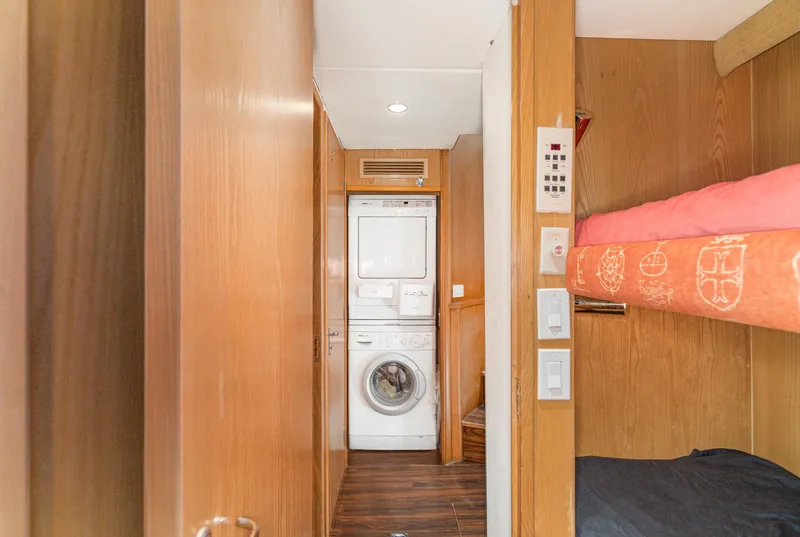 Slide: The Image of 1996 Hatteras 70 Sport Deck Motor Yacht interior with bunk beds and laundry area. - 21