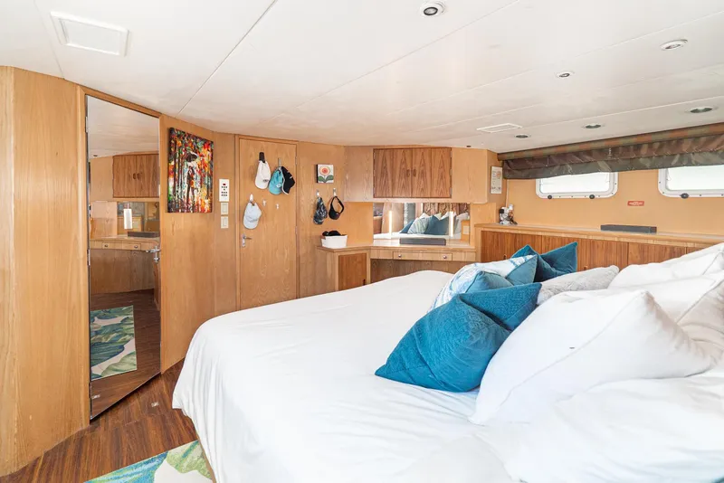 Slide: The Image of Luxurious bedroom interior of 1996 Hatteras 70 Sport Deck Motor Yacht with wood accents. - 25