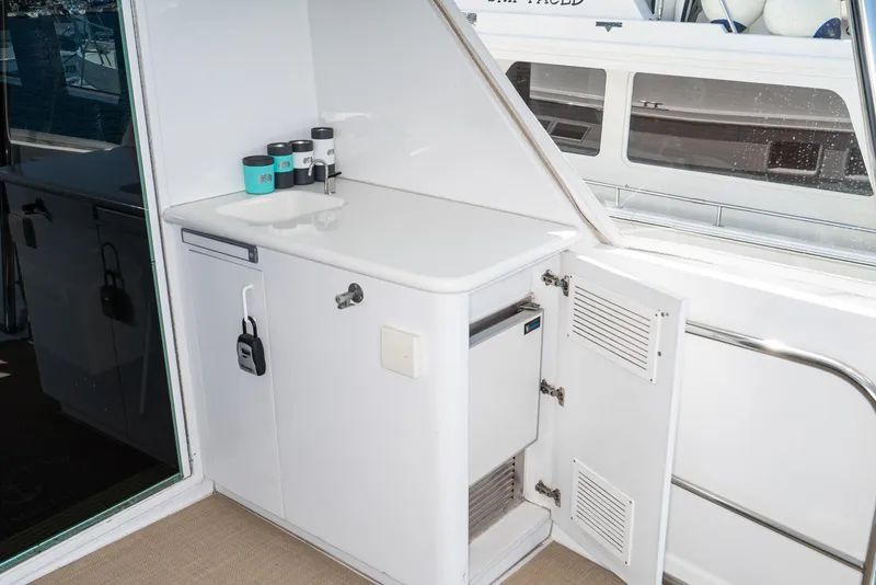 Slide: The Image of 1996 Hatteras 70 Sport Deck Motor Yacht interior with white cabinetry and storage space. - 37