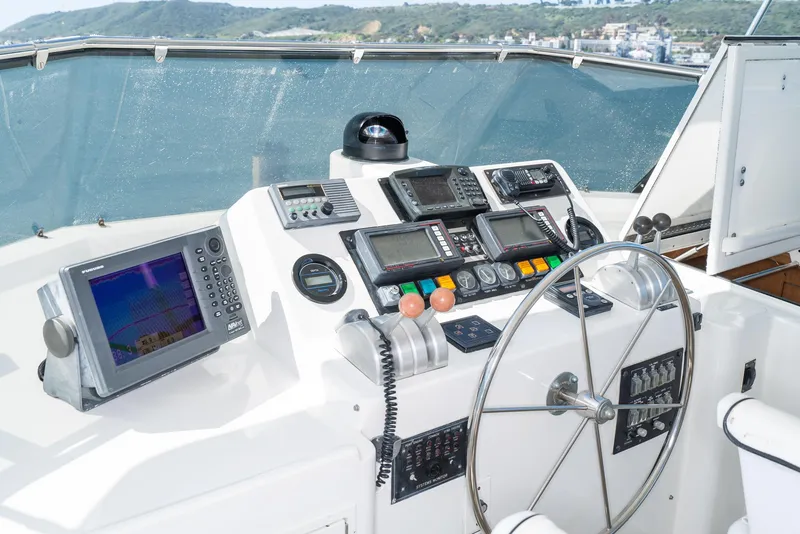 Slide: The Image of 1996 Hatteras 70 Sport Deck Motor Yacht helm with navigation equipment and steering wheel. - 39