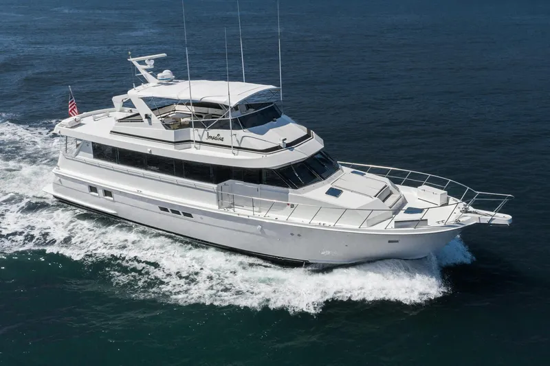 Slide: The Image of 1996 Hatteras 70 Sport Deck Motor Yacht cruising on open water. - 44