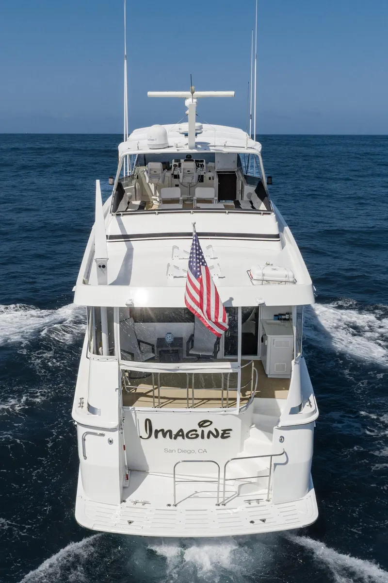 Slide: The Image of 1996 Hatteras 70 Sport Deck Motor Yacht cruising on open water, rear view. - 47