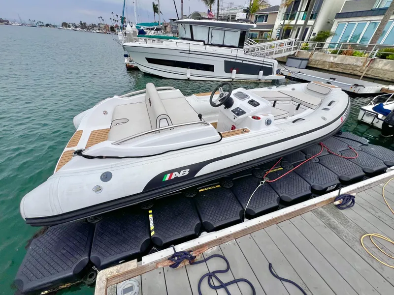 Slide: The Image of 2023 AB Inflatables ABJET 430XP docked, sleek design, luxury inflatable boat, waterfront setting. - 6