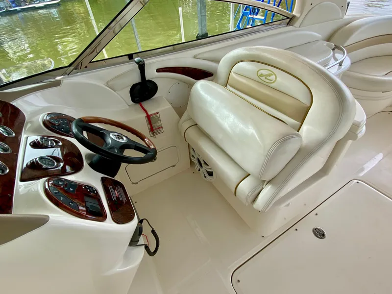 Slide: The Image of 2001 Sea Ray 290 Bowrider cockpit with white leather seats and wood-accented controls. - 15