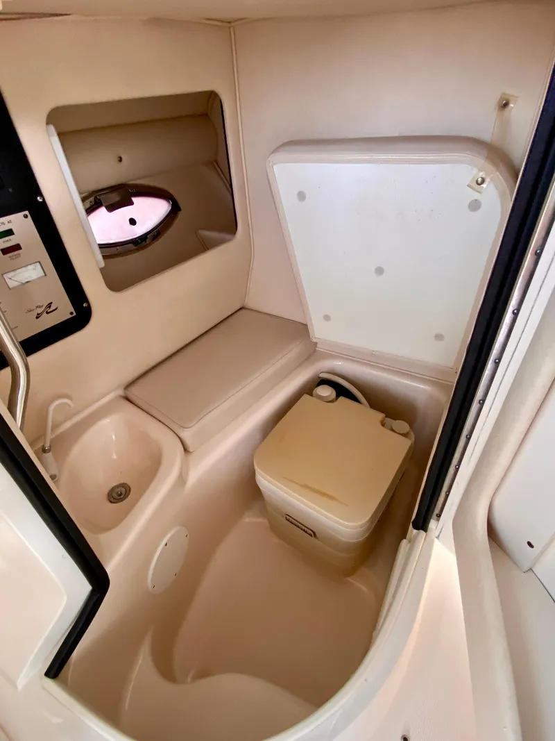Slide: The Image of 2001 Sea Ray 290 Bowrider interior with compact bathroom and sink. - 18