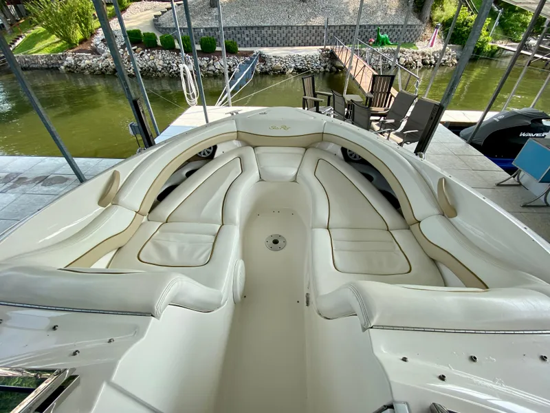 Slide: The Image of 2001 Sea Ray 290 Bowrider with spacious seating, docked by a serene waterfront. - 24
